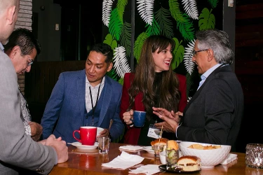 Attendees toasting at a networking dinner table